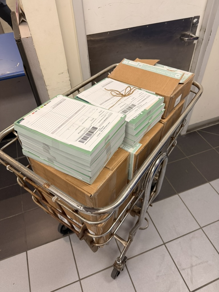 Bundled Hill Country Highlight mailers loaded on a cart at the post office
